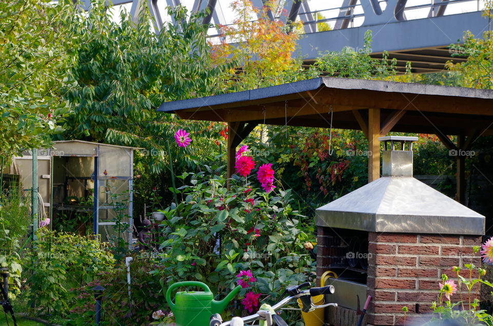 Urban gardening in the Park am Gleisdreieck where people have their small garden for more than 30 years now. After a huge transformation of the surrounding area the gardens have been integrated into the park design. Together with the metro which is lead along the bridge in the background of the image.