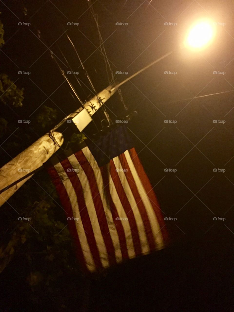 American flag at night under a street light. 