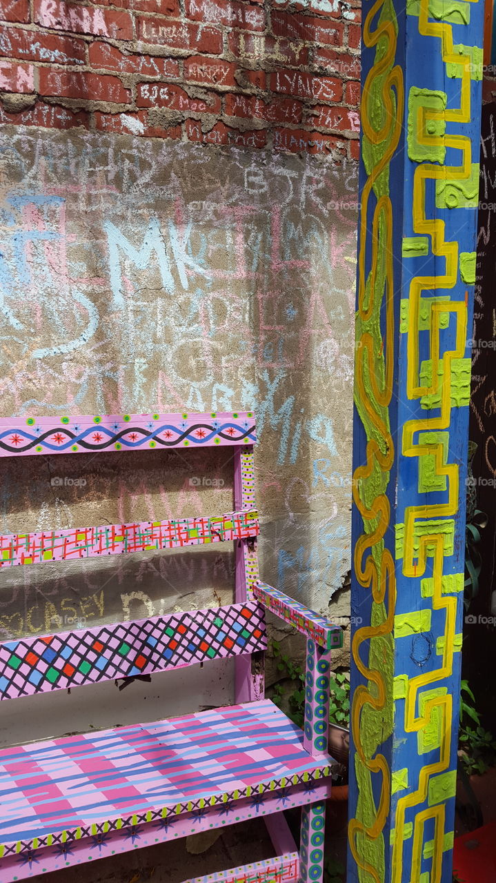 colorful bench next to post with chalk background