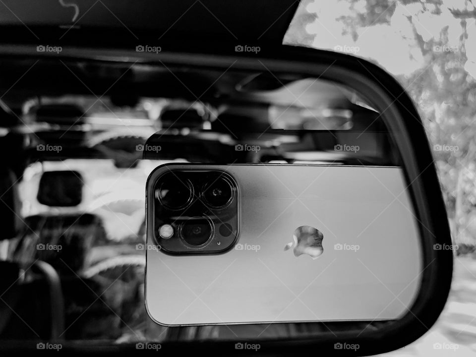 Reflection of iPhone 13pro in car rear view mirror 