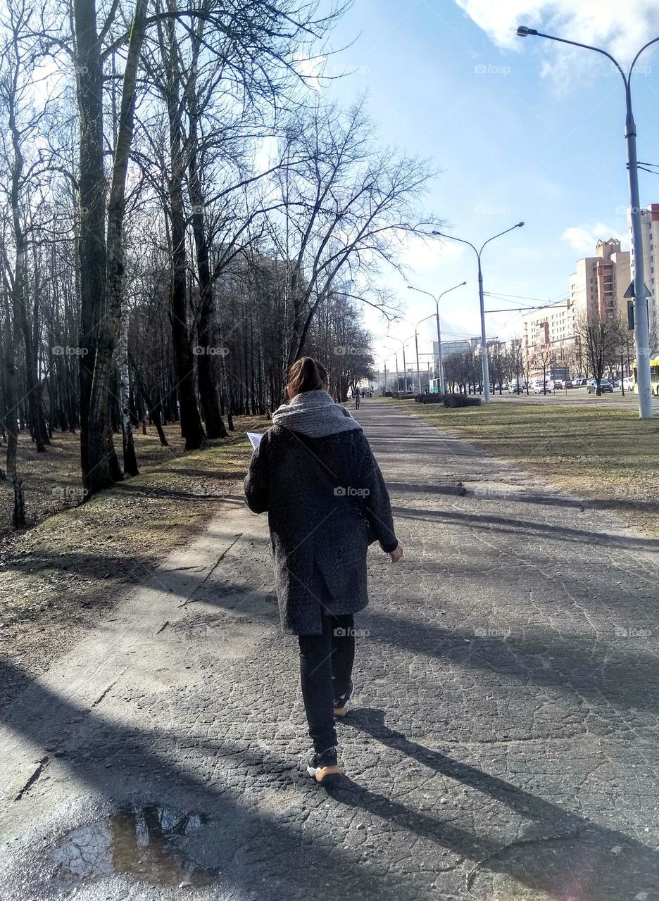 girl walking on a street spring time city view