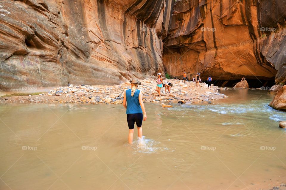 Women hiking through the river in Zion Narrows 