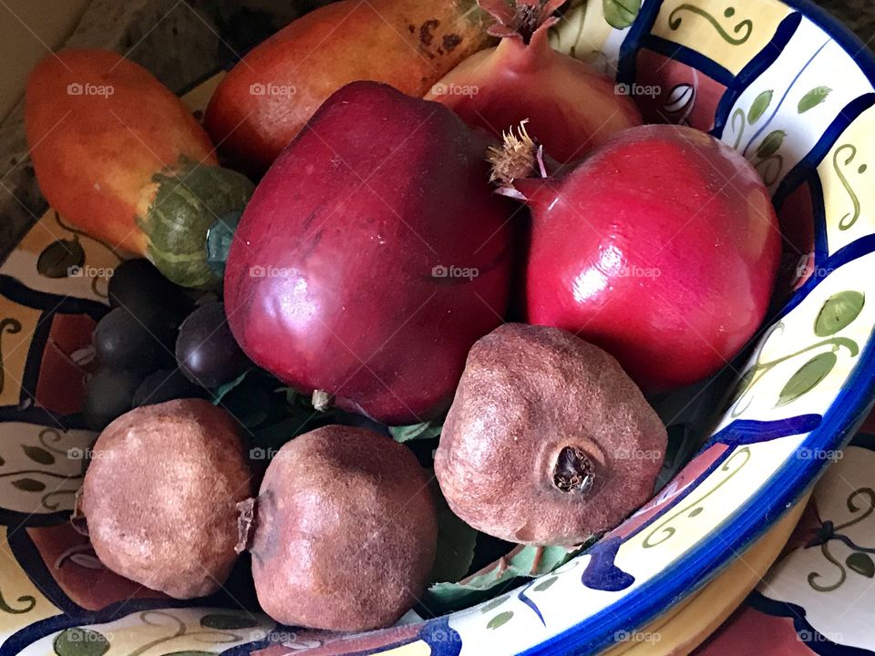 A pottery bowl of small potatoes and red onions 