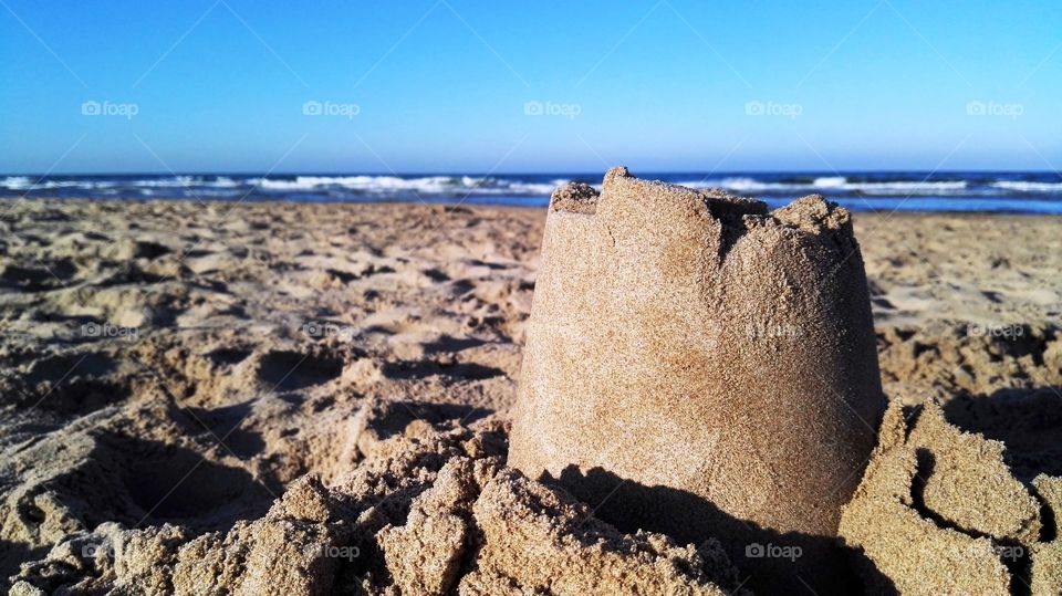 a castle tower made of sand in the beach
