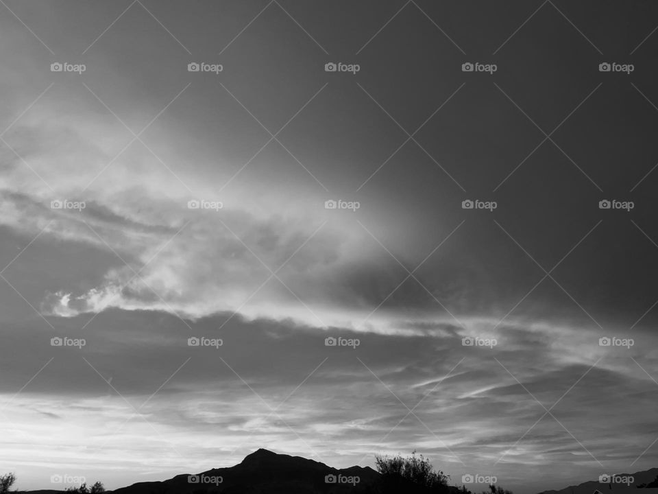 A black and white photo of mountains and clouds.  