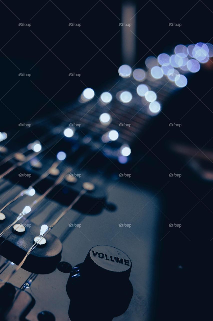 electric guitar with garland lights instead of strings and slight bokeh.