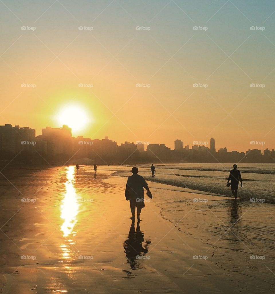 🇧🇷 Litoral do Brasil - praia de Santos, com a silhueta das pessoas em caminhada à beira-mar ao amanhecer. / 🇺🇸 Brazil Coastline - Santos Beach, with silhouette of people on seaside walk at dawn.