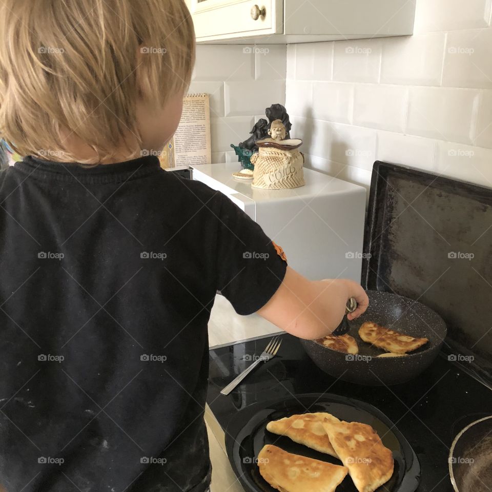 Cute little Boy is cooking breakfast for family 