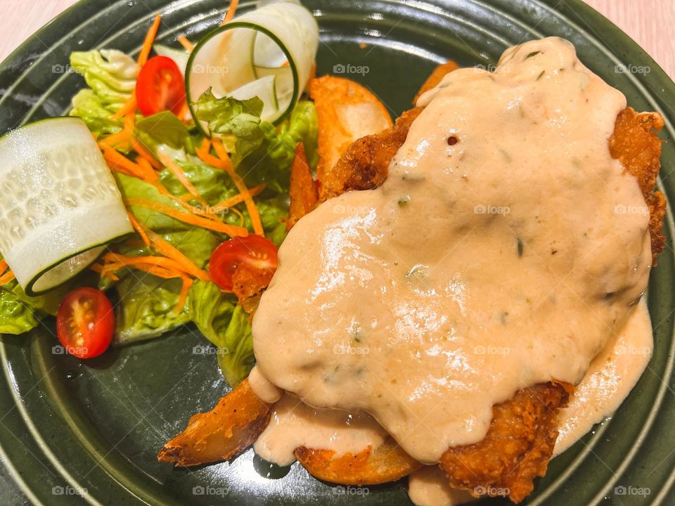 Delicious butter cream chicken with veggies and also fries.