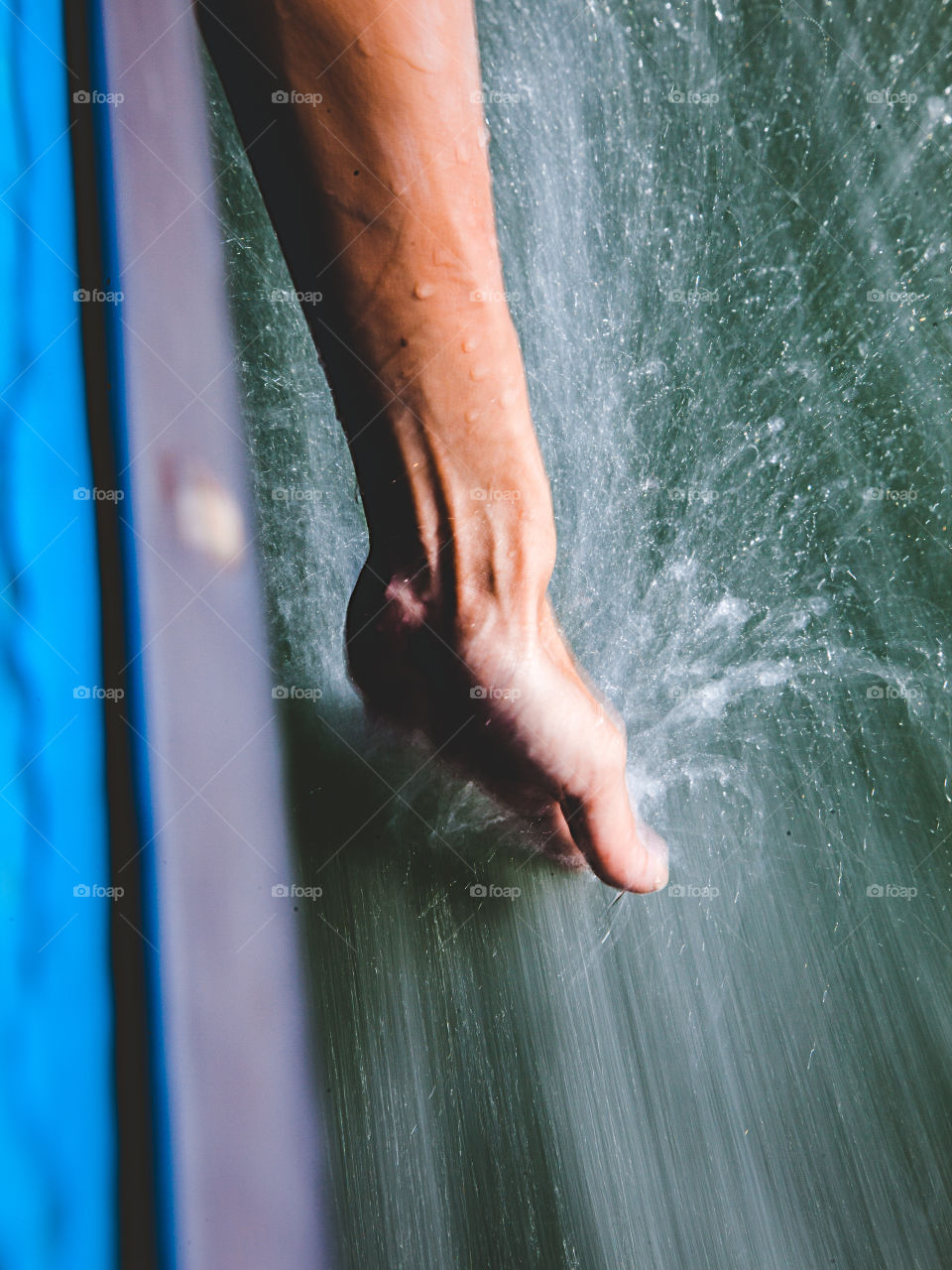 Close-up of person's hand splashing water