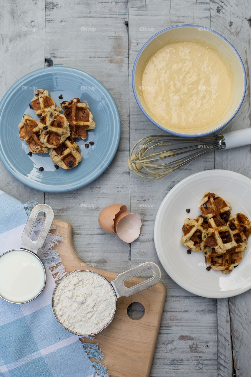 Breakfast waffles and ingredients on wood