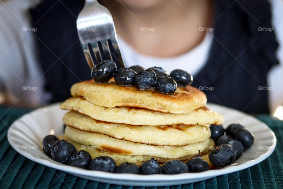 Child is eating pancakes