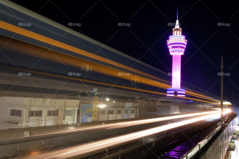 Light of Electric train BTS when reach to station on beautiful background of City tower of Samut Prakan province,Thailand