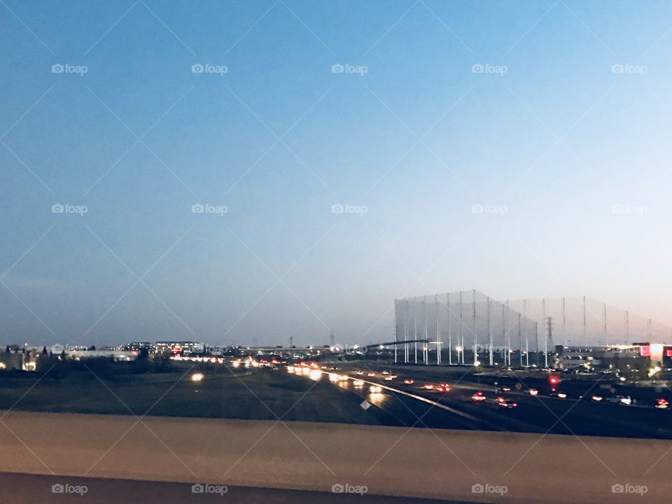 Driving at night over the freeways overpass with the bright lights of the passing cars. USA, America 