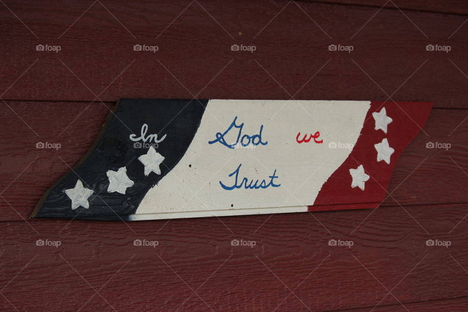 Red, white and blue plaque with "in God we trust" writing