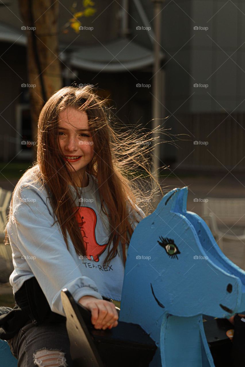 girl riding a big rocking horse