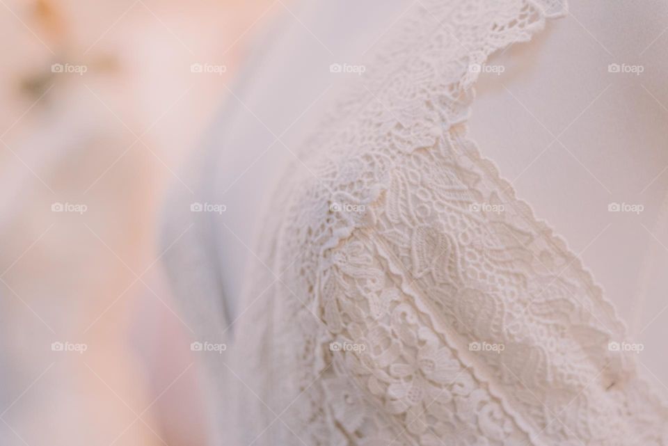 Detail of a white linen wedding dress. Lace.