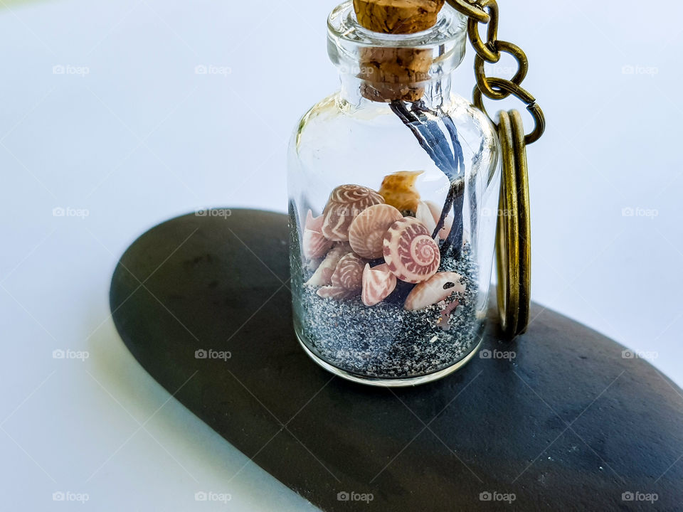 real seashells with sand in a tiny bottle