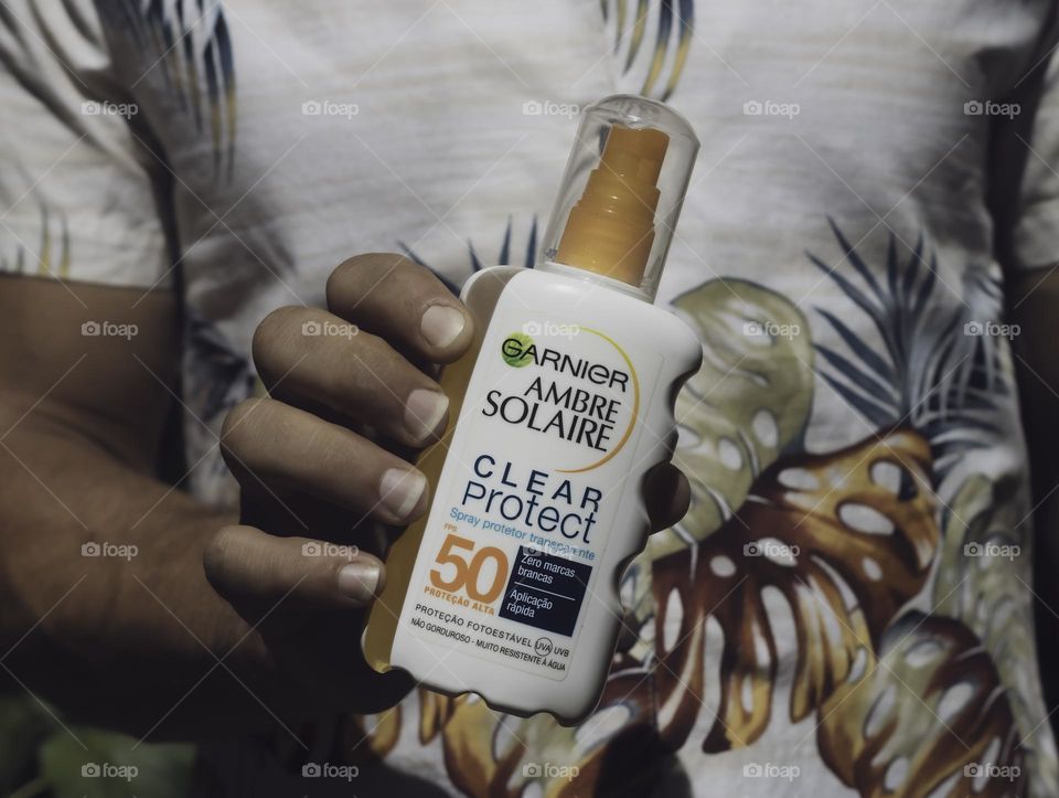 Man wearing vintage Hawaiian shirt and holding sunscreen 