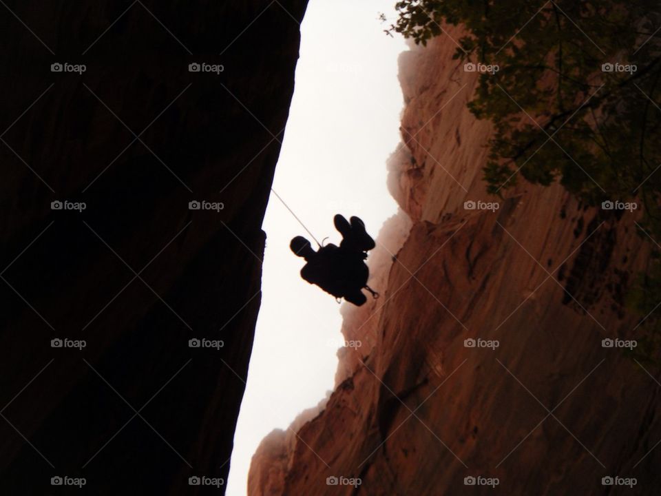 Man Rappelling in Enclosed Canyon