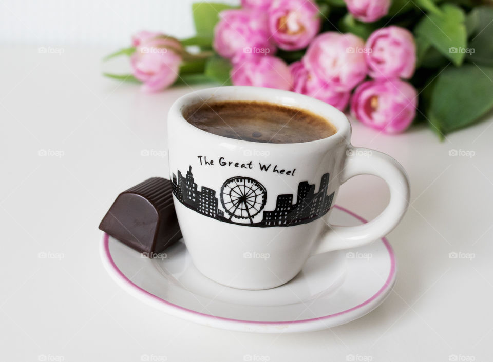 Coffee cup, little chocolate and pink flowers