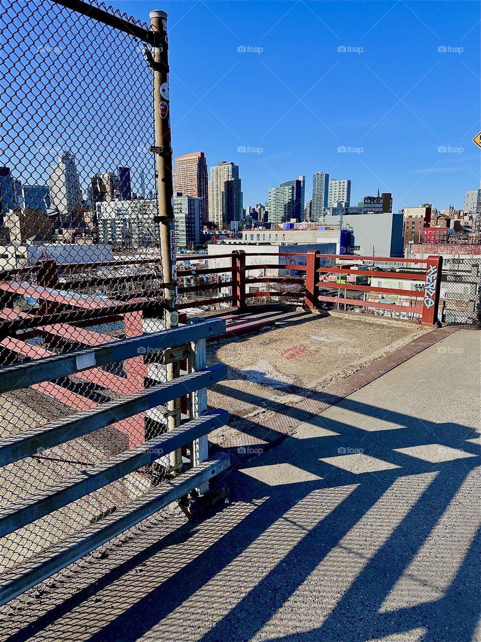 The intense shadows on the „Pulaski Bridge“ at „Newtown Creek“ that connects „Greenpoint“, Bklyn to LIC often create intricate patterns when combined with the structures of the bridge such as in this crisscross example here. 2024. Hypnotic Productons