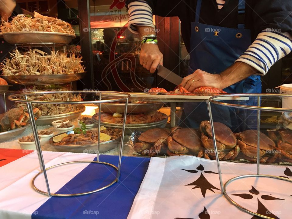 Man cutting lobster at a seafood stall 