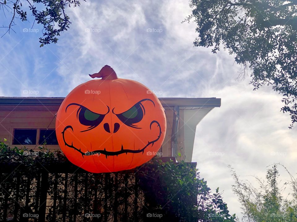 Giant inflatable jack o’ lantern on home balcony 