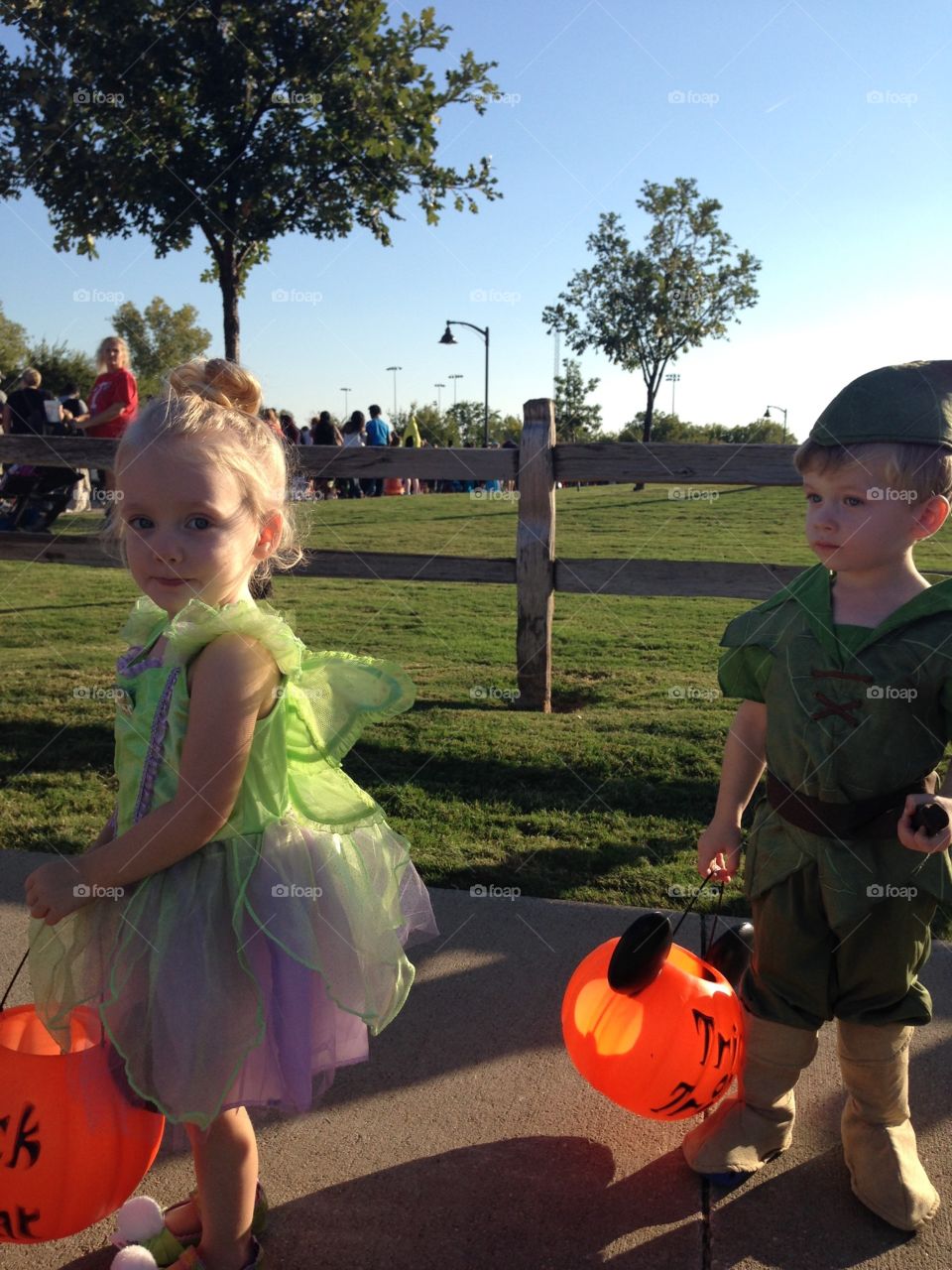 Twins trick or treating. Toddlers on Halloween. Peter Pan and Tinker Bell