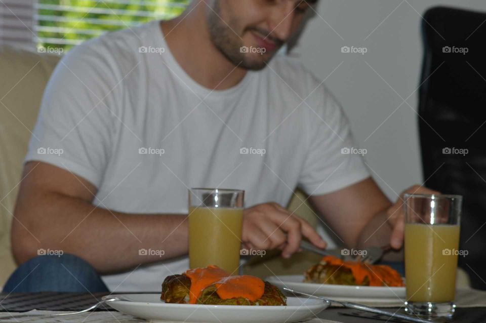 Man eats dinner 'Golabki' with tomato sauce - Polish flavors