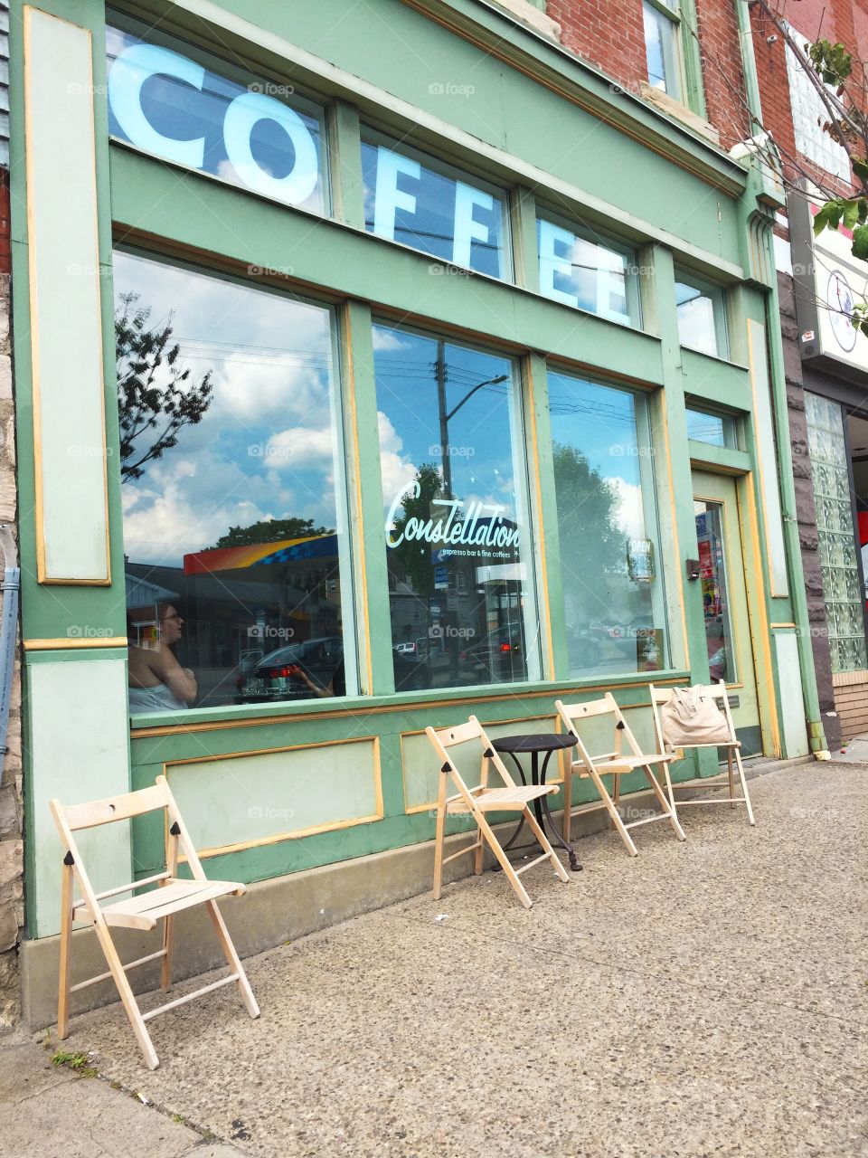 Street view of coffee shop with green window frames 