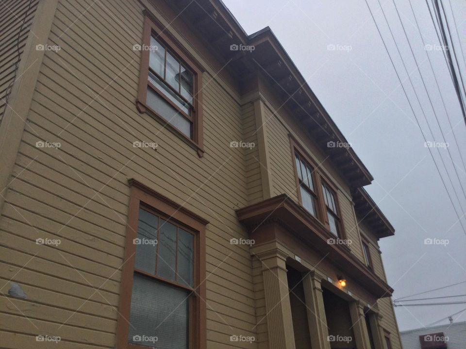 An Old Yellow Victorian Era Home with red Trim
