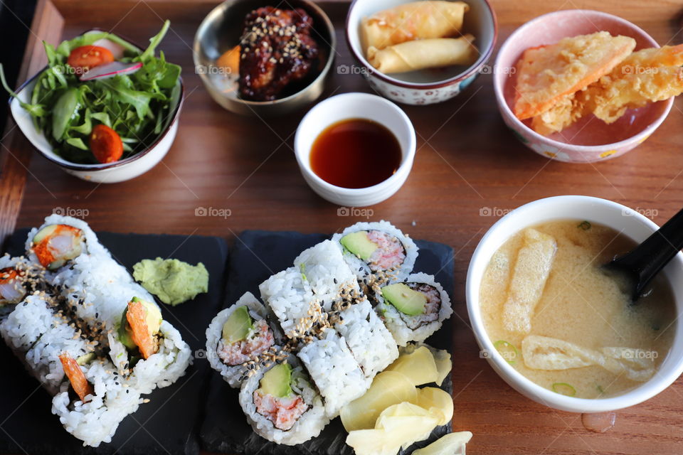 Assemble of sushi and different okazu (appetizers) on wooden tray . Japanese cuisine 