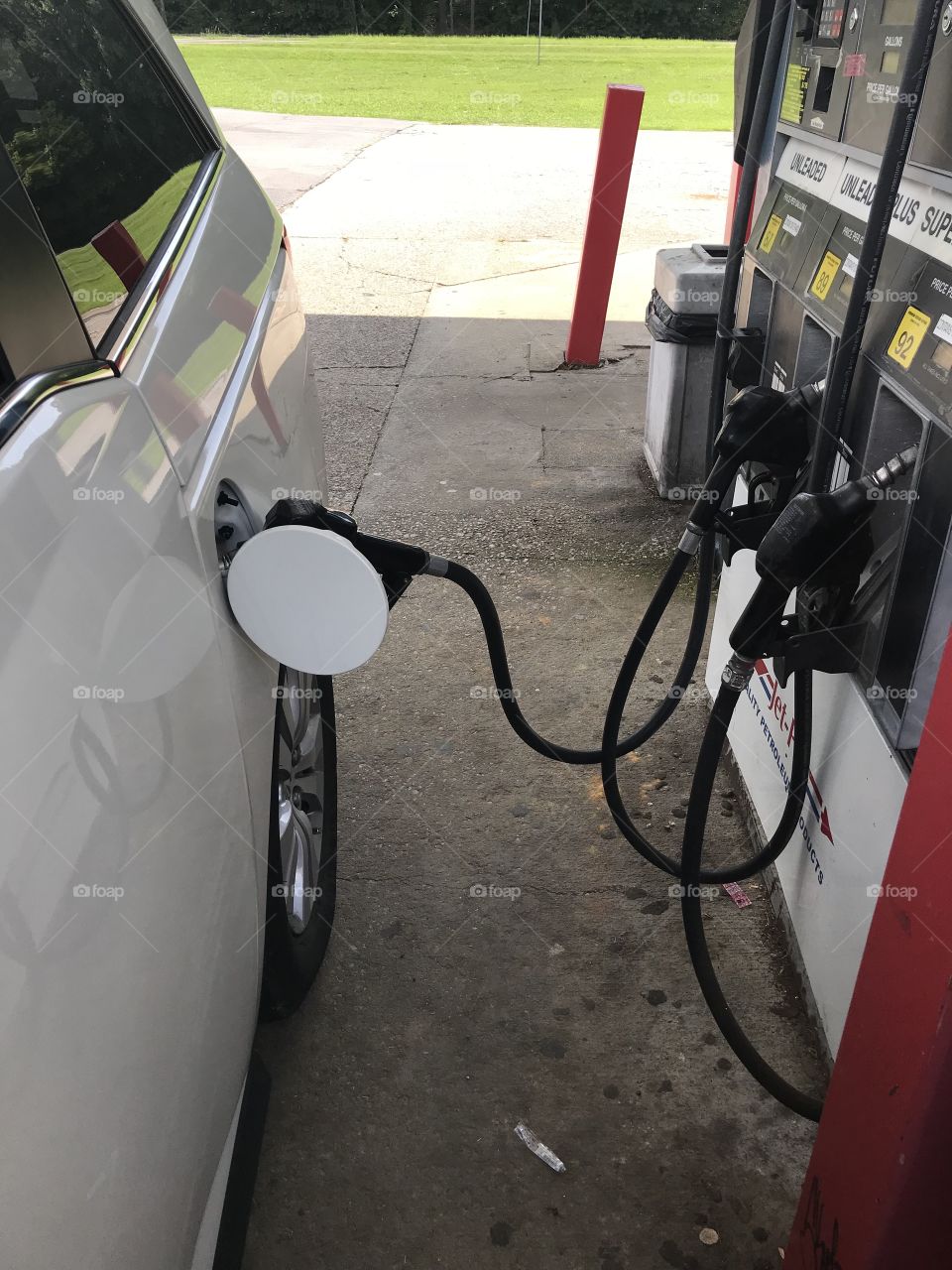 This white vehicle is getting filled up with gas, so we can go on an adventurous road trip. 