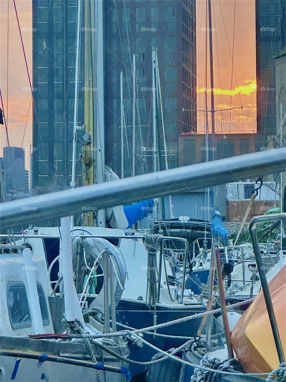 Sunsets at “Newtown Creek” by the “Pulaski Bridge” in LIC, Queens can be spectacular such as this brightly orange red glowing scenario peeking out at us from between two newly erected LIC high rises. 2024. Hypnotic Productions