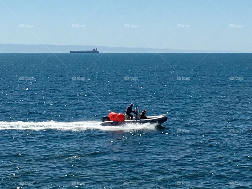 Man in outboard boat on ocean on way to set crab traps