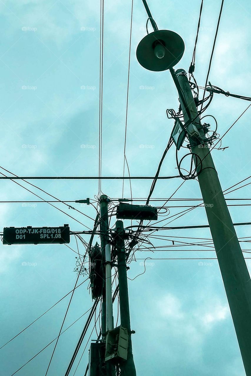 Too many wires on the electricity pole in low angle view