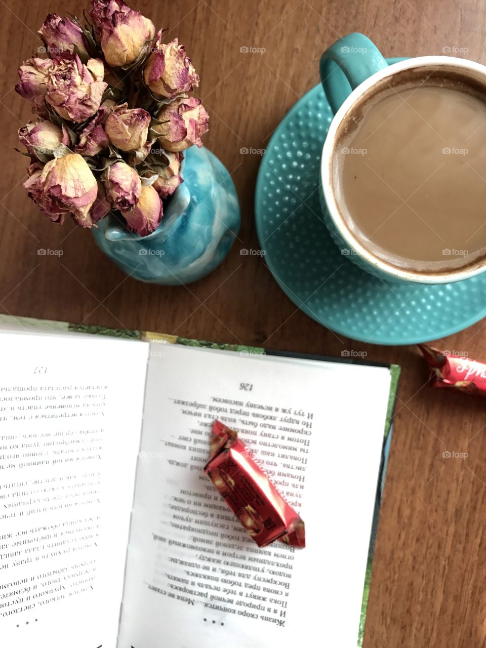 Table from above , coffee cup book and flowers 