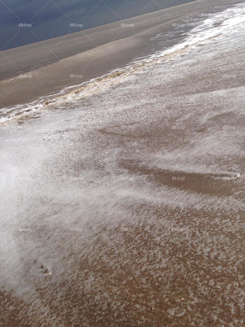 Ebbing sea over sand