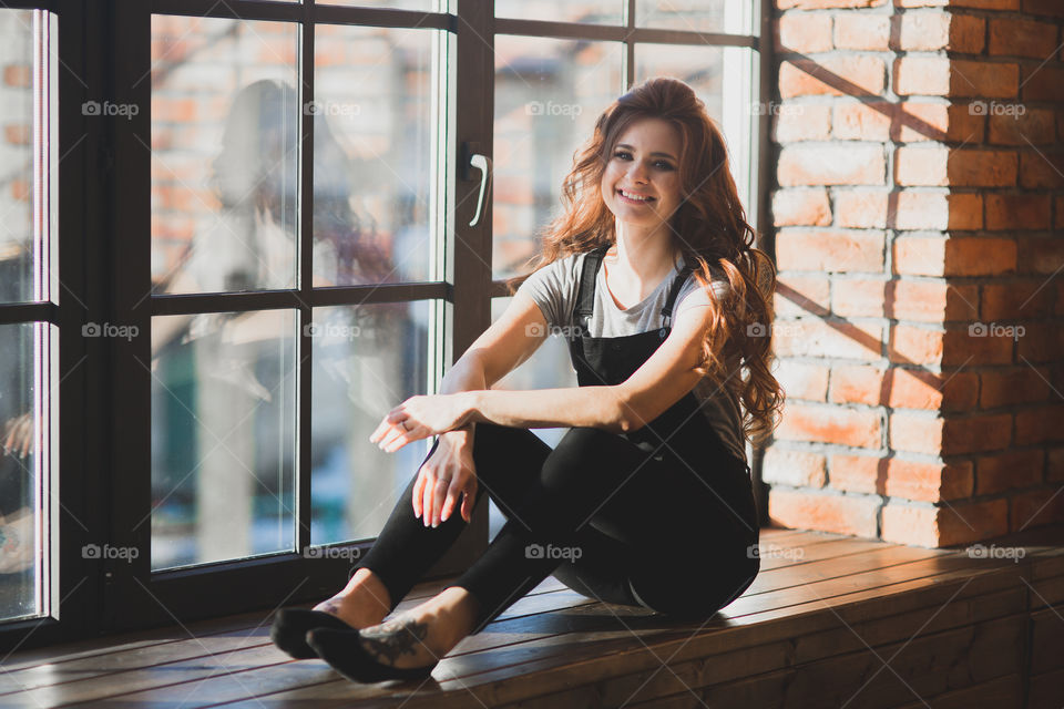 Portrait of young beautiful woman near window