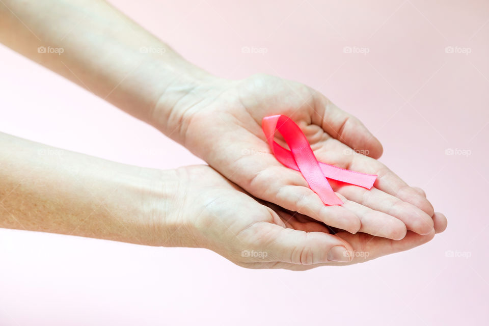 Breast cancer awareness campaign, hand holding the pink ribbon
