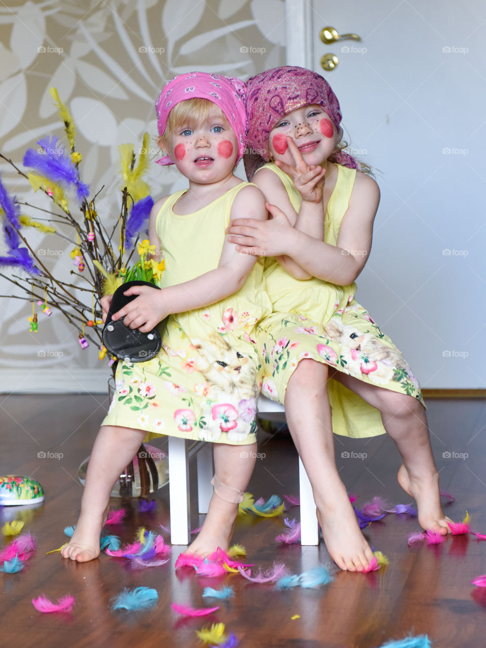 Two young sisters having fun infront of the camera with easter theme.