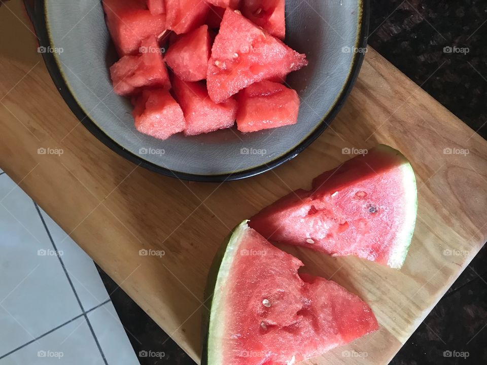 Red, juicy and delicious cut up Watermelon in a bowl and cutting board in the kitchen.  Eating healthy for my news years resolutions. USA, America 