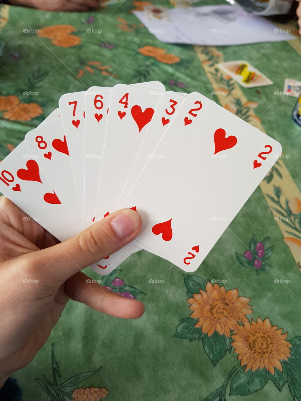 playing with cards deck hearts game hand table.