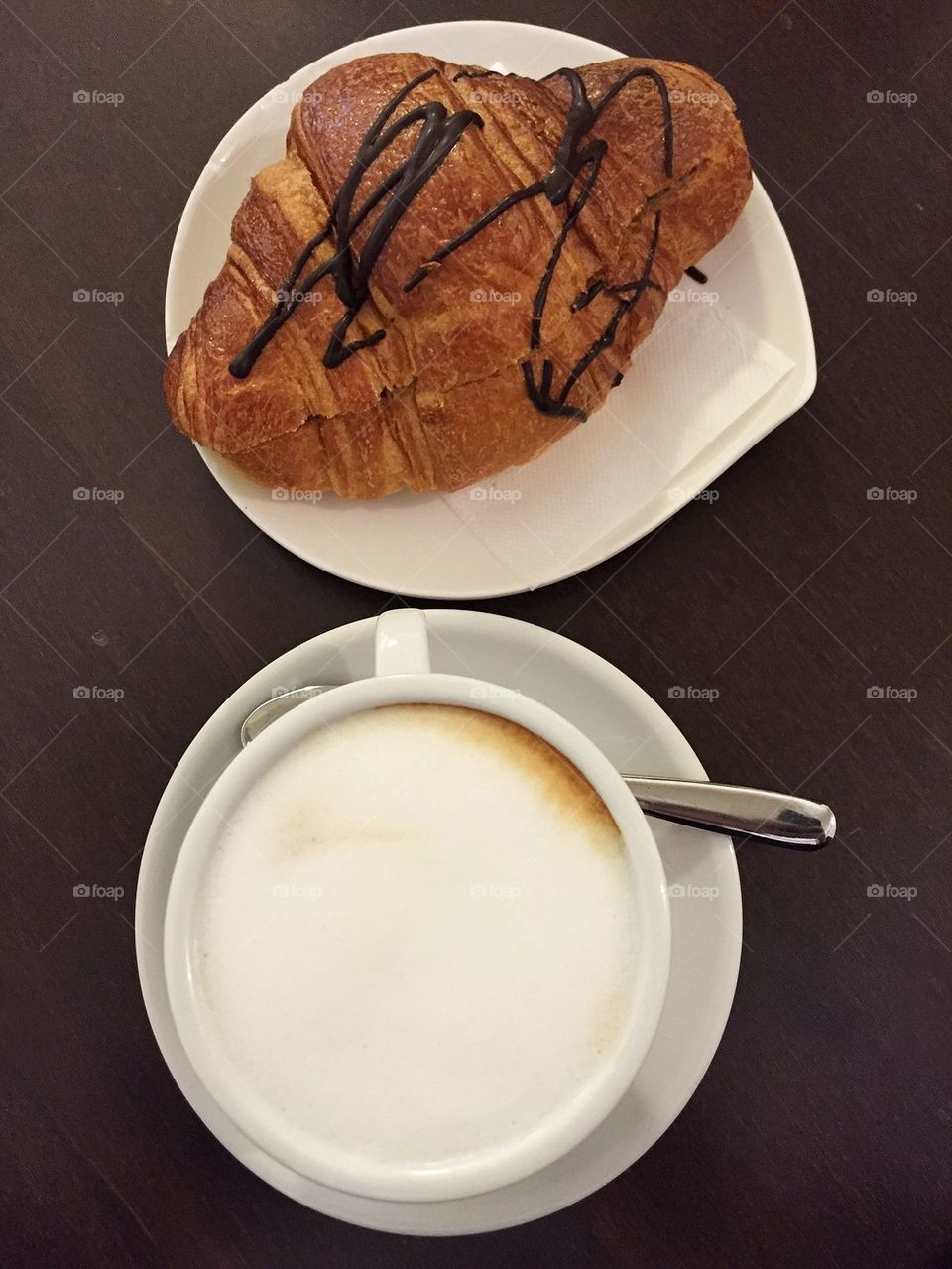 Cappuccino with chocolate croissant at the bar