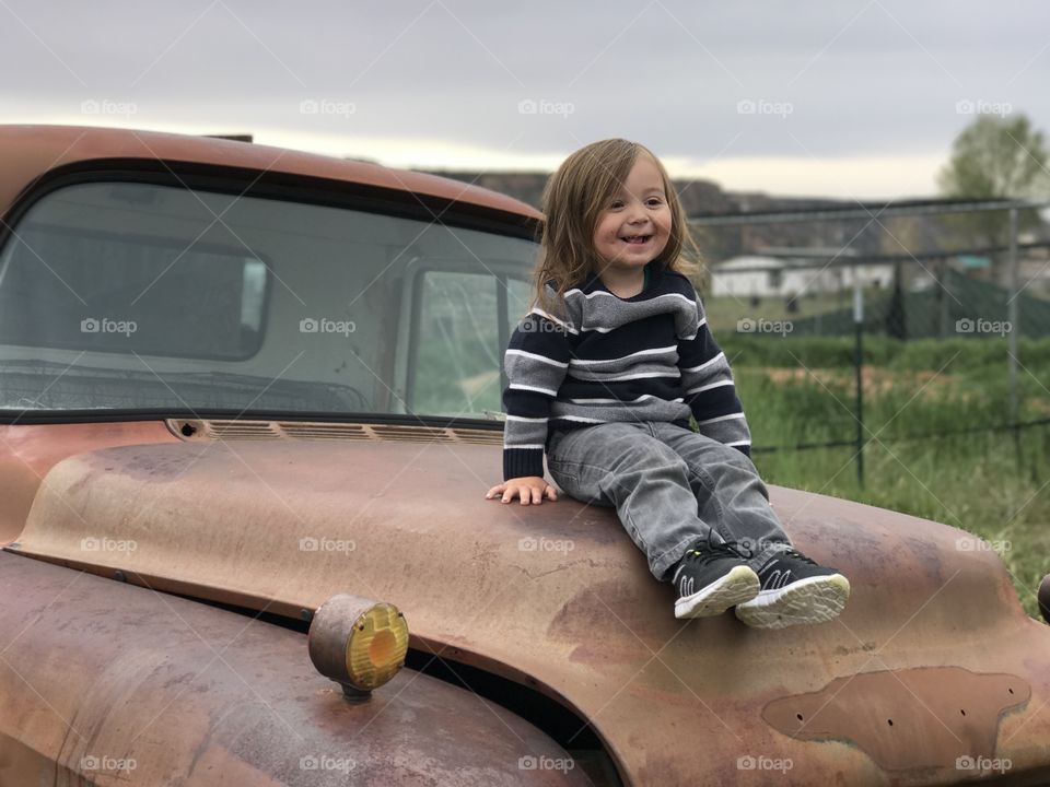 Little girl sitting on old vintage car