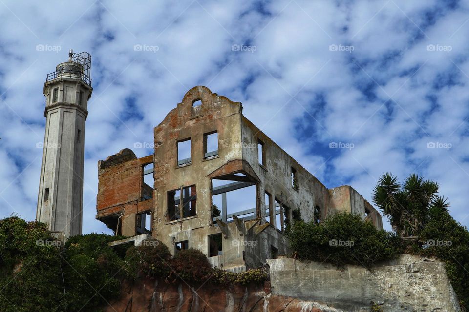 Ruins of the warden’s house on Alcatraz Island with intense blue skies with clouds that look like dots of cotton balls 