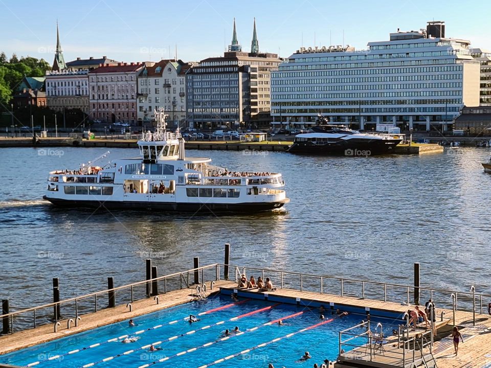 Urban nature - Water: facade of the European city over the bay with passenger boat and open swimming pool