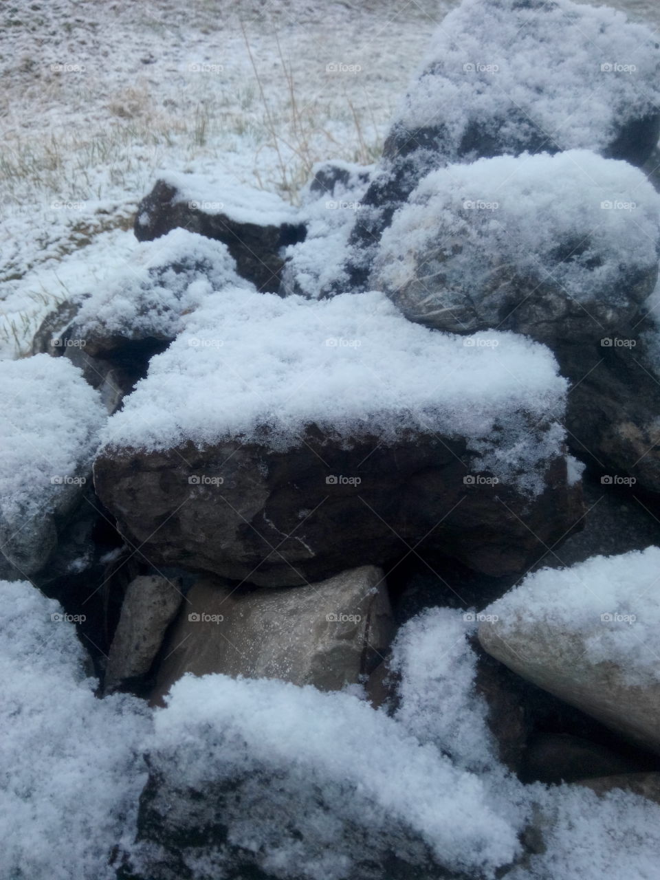 Snowy rocks. Grey rocks with gentle cover of snow