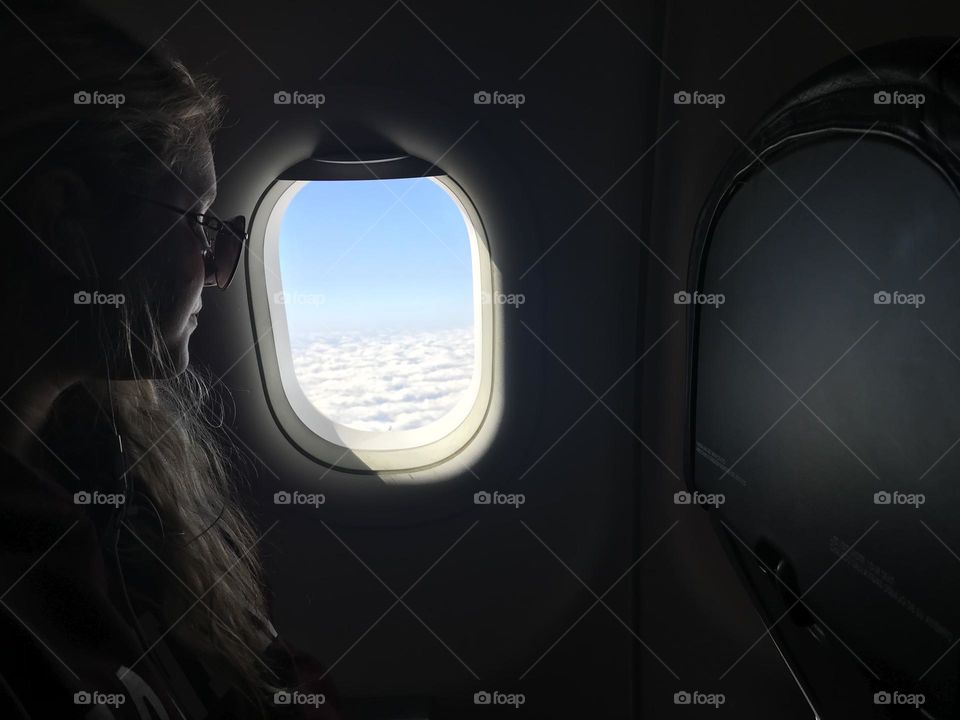 Girl looking out airplane window 